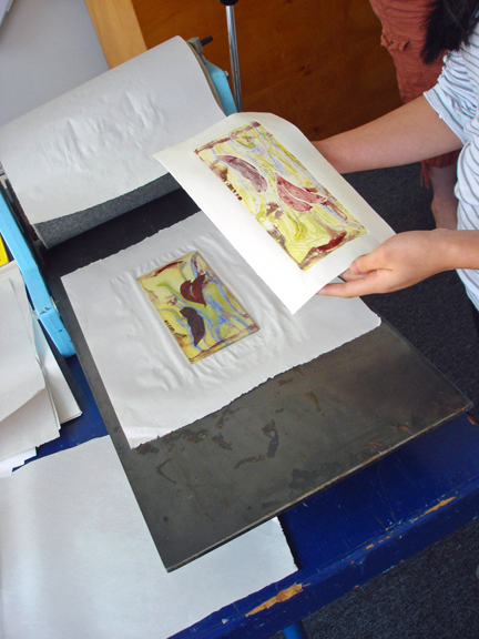 Artist pulling her print from the plate.