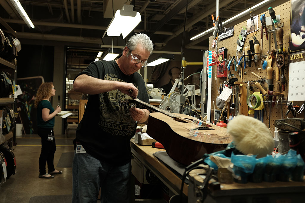 Brian E. Pritchard strings a custom guitar. Mark Markley photograph