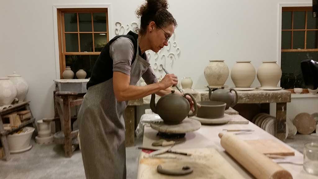 Linda Sikora works on a teapot in her studio