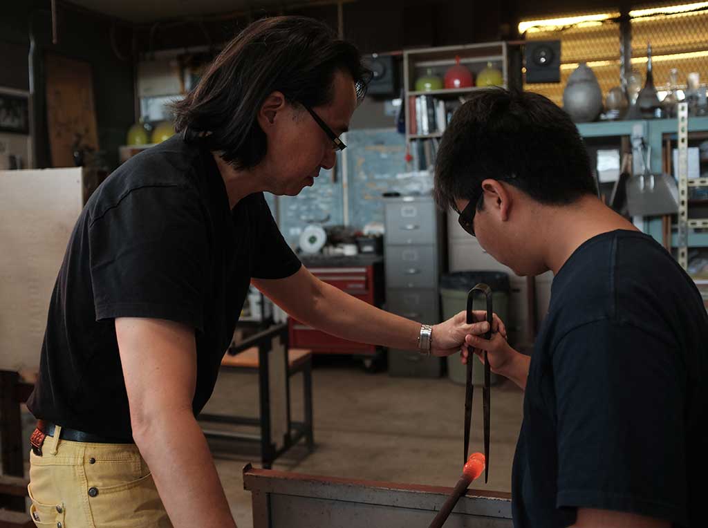 Mark Mitsuda assists a student. Mark Markley photograph