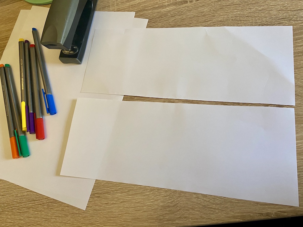 Cut (or fold and tear) a piece of paper in half lengthwise to make two long, skinny rectangles.