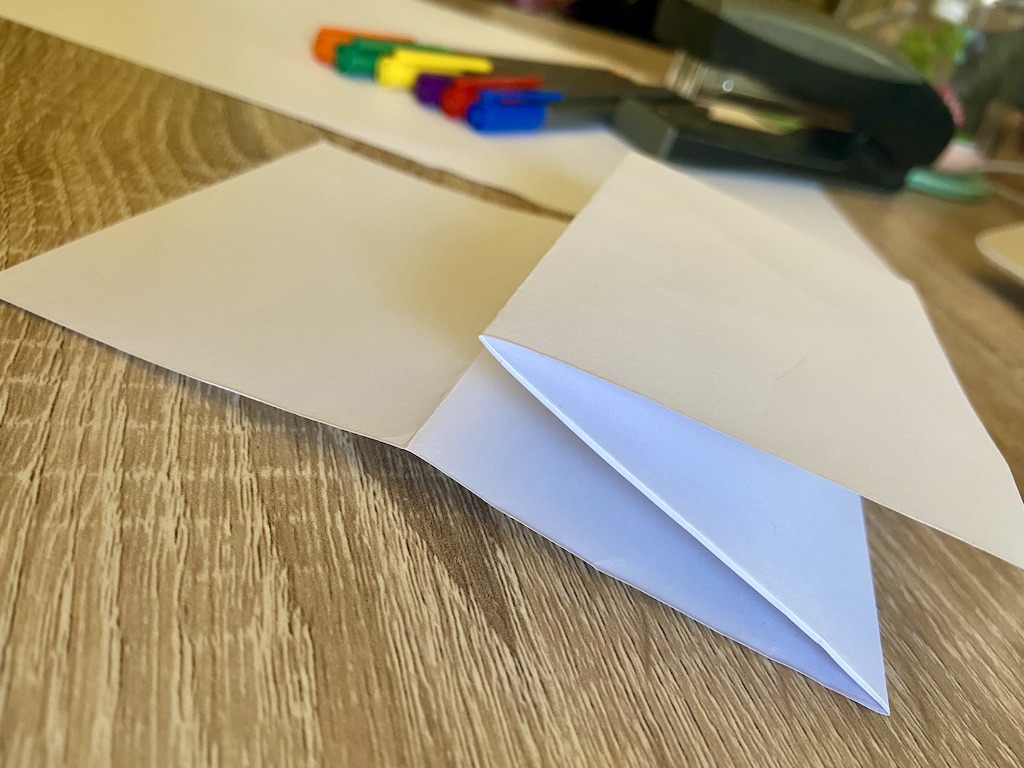 Fold the top flap in half again, with the bottom edge of the paper meeting the first top crease.