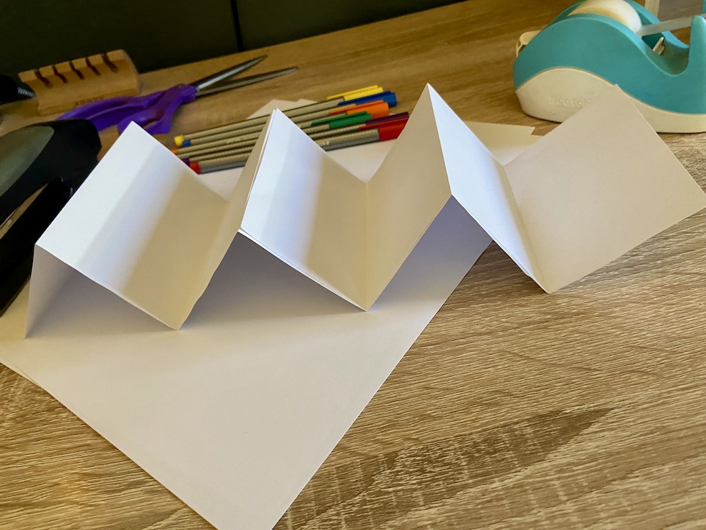 Glue your Ws together to make an accordion (or use tape if you don’t have glue). If you are using a thick type of paper, you might want to use a heavy object like a book to press down on top of it for a few minutes.