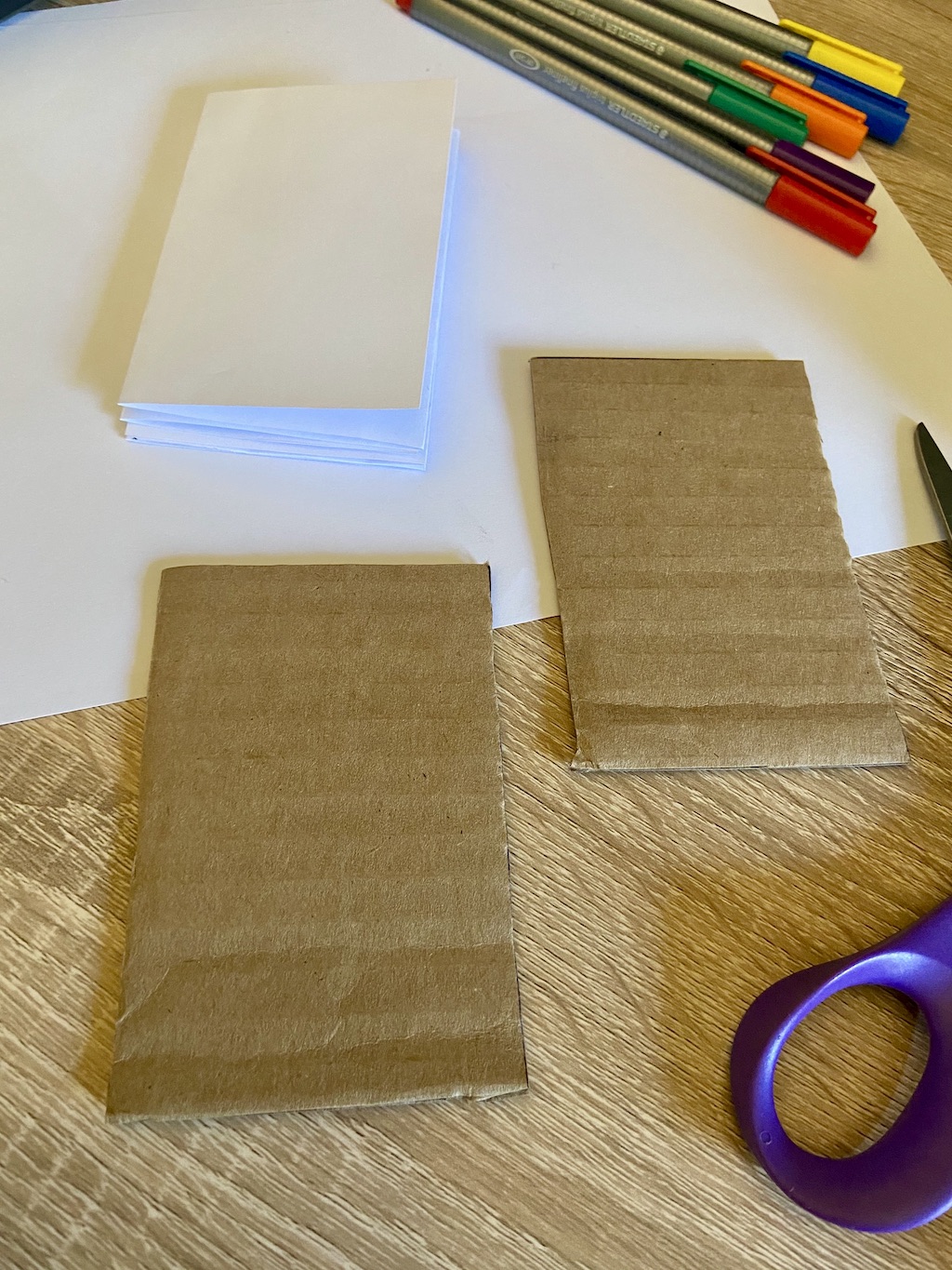 To make your book cover, take two pieces of cardboard or cardstock (you can cut up cereal boxes too!) and cut them to the same size as the accordion. 