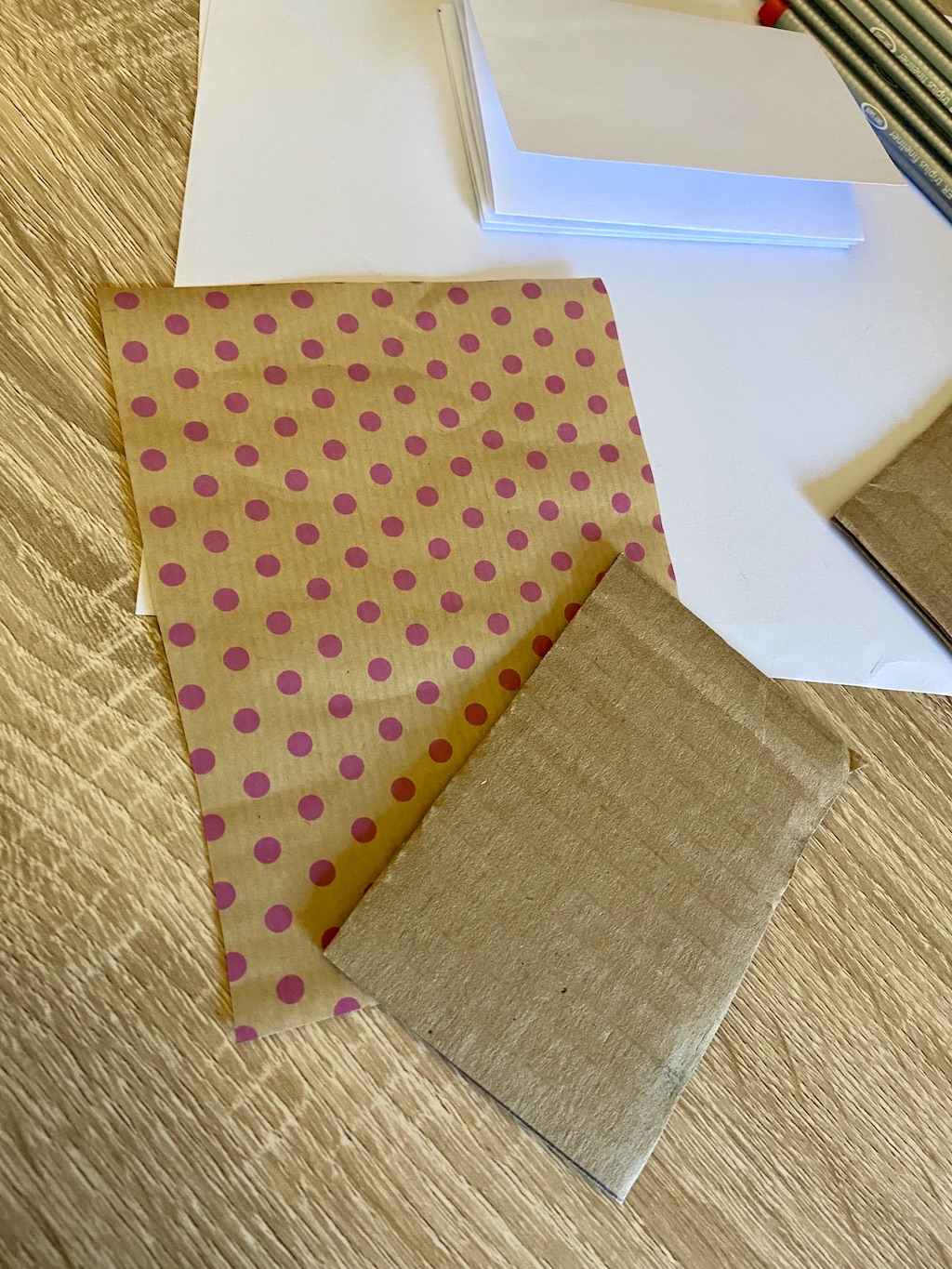 Take your decorative or scrap wrapping paper and cut two pieces a little larger than the cardboard, about an inch or two bigger on each side.