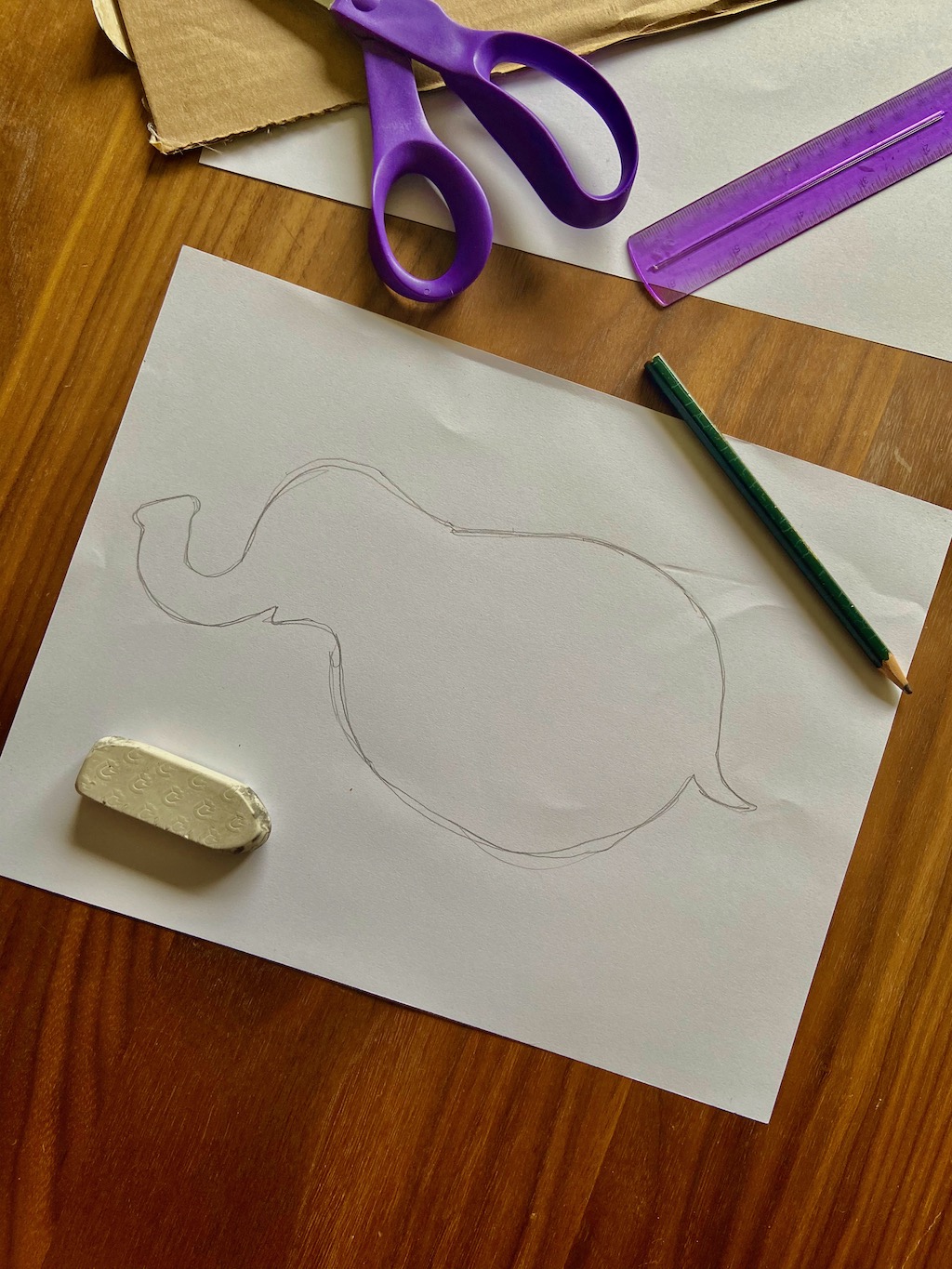 Sketch out the basic shape of the elephant’s side view onto a piece of paper or directly onto the cardboard - do not include any limbs or large features. This is our base shape.