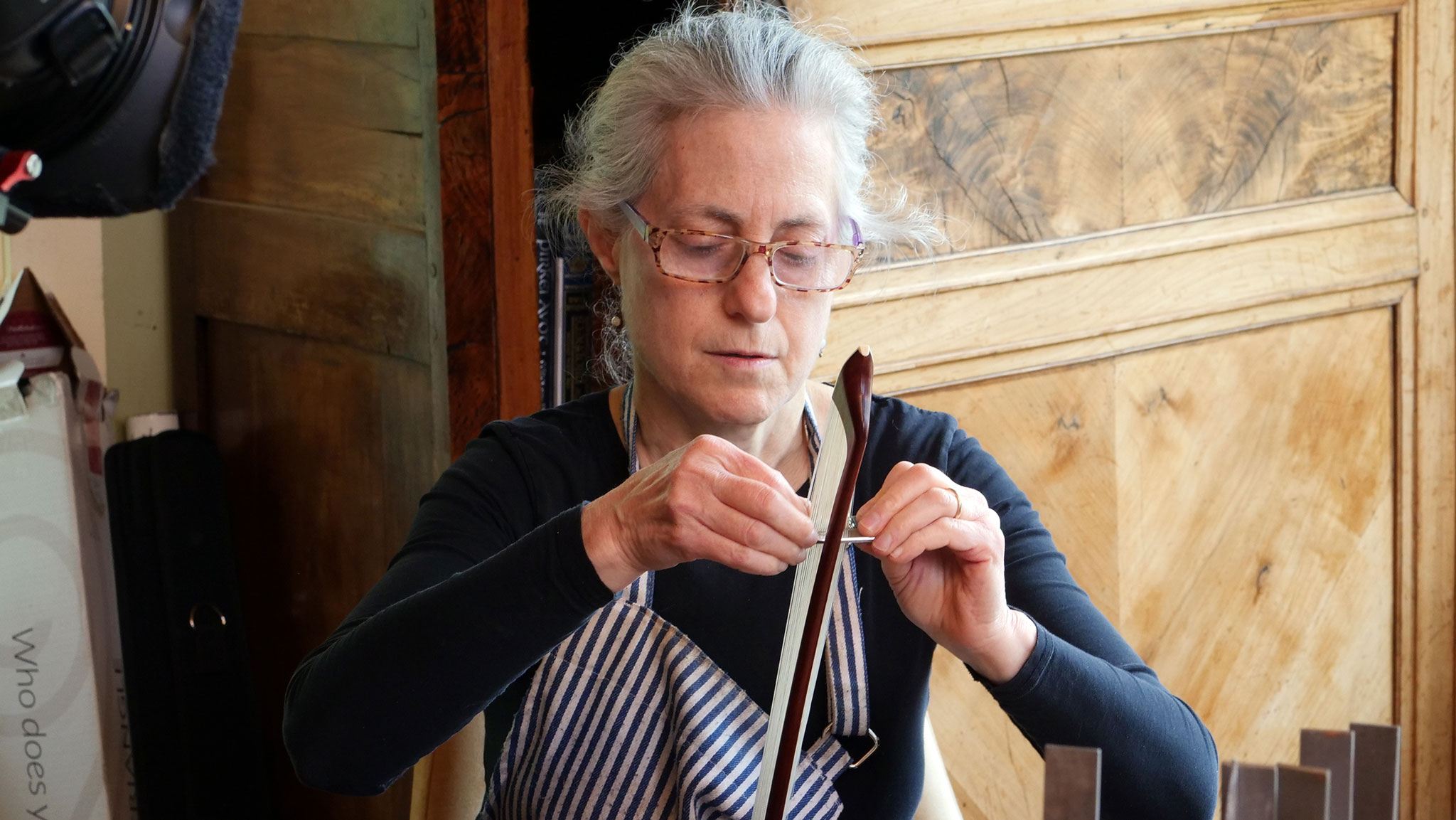 Bowmaker Susan Lipkins rehairs a bow. Denise Kang photo. HARMONY episode of Craft in America