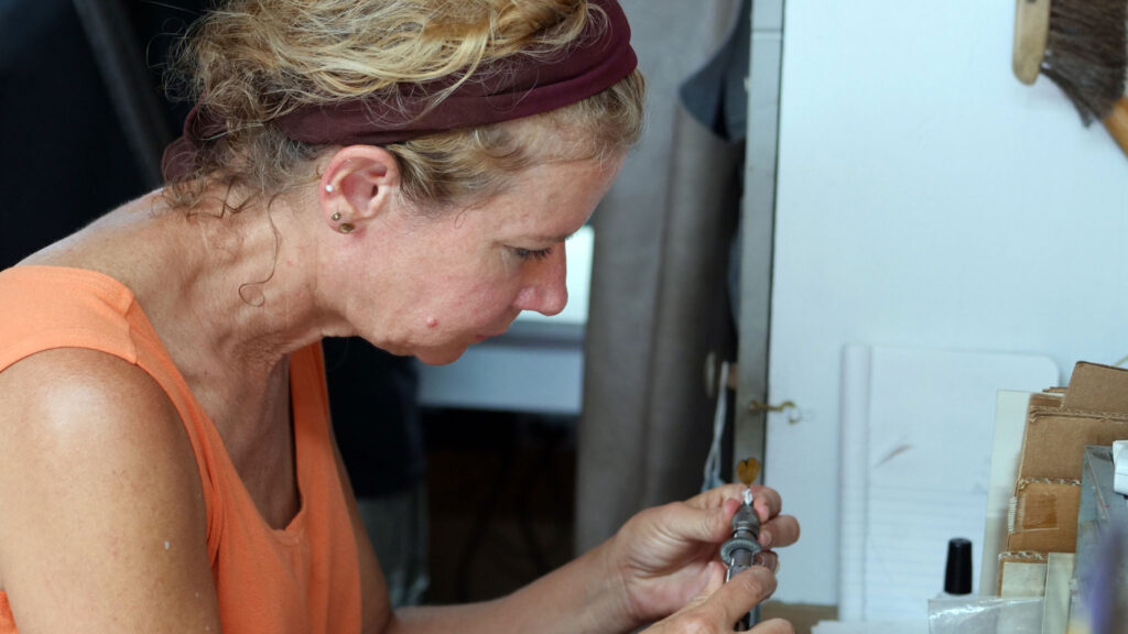 Gabrielle Gould works with bird feathers in her jewelry. Denise Kang photo. JEWELRY episode of Craft in America
