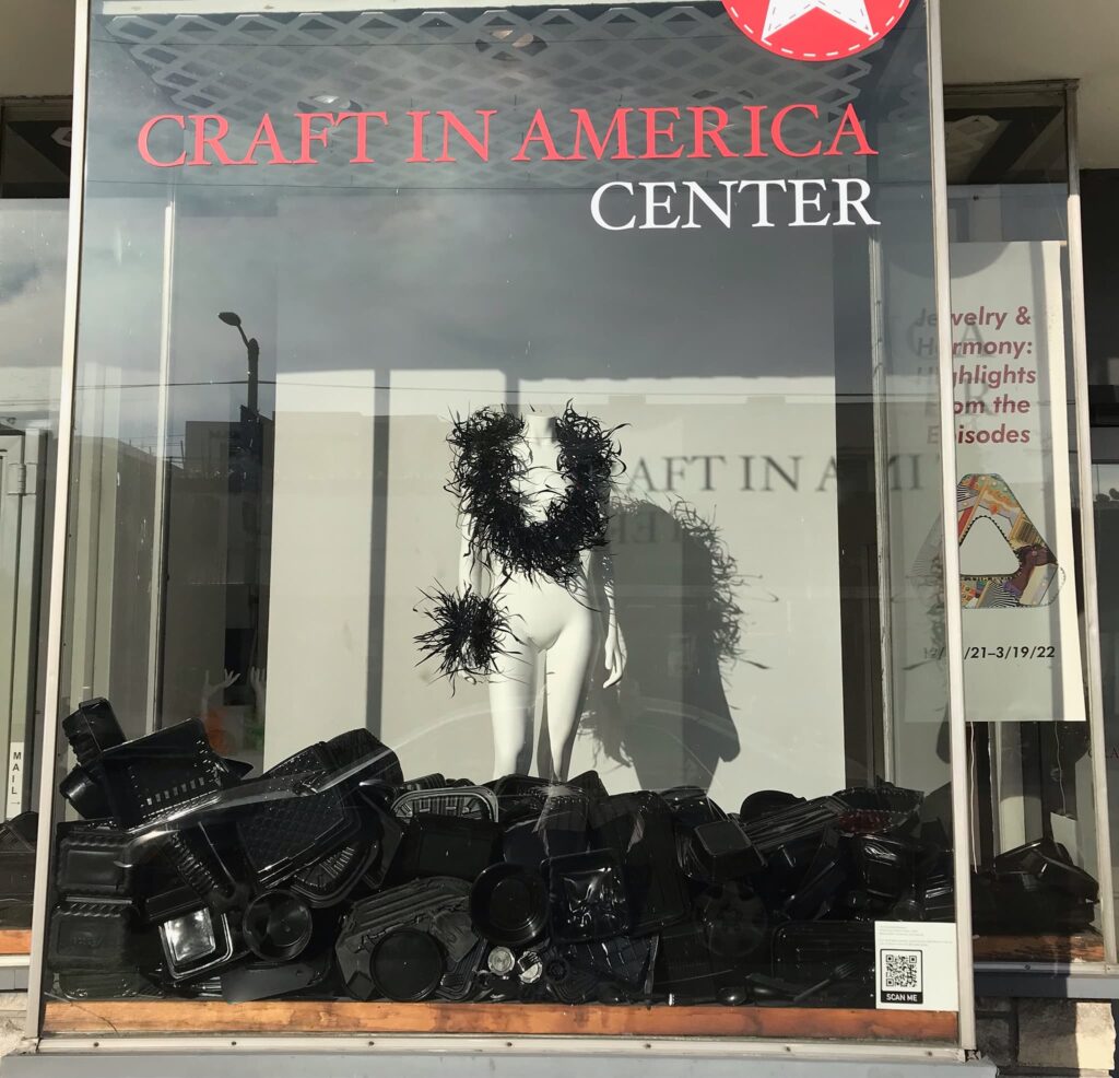 Harriete Estel Berman window Installation of Black Plastic Gyre Necklace (2018) and Black Plastic Bracelet, (2012).  at the Craft in America Center. Craft in America, Jewelry and Harmony
