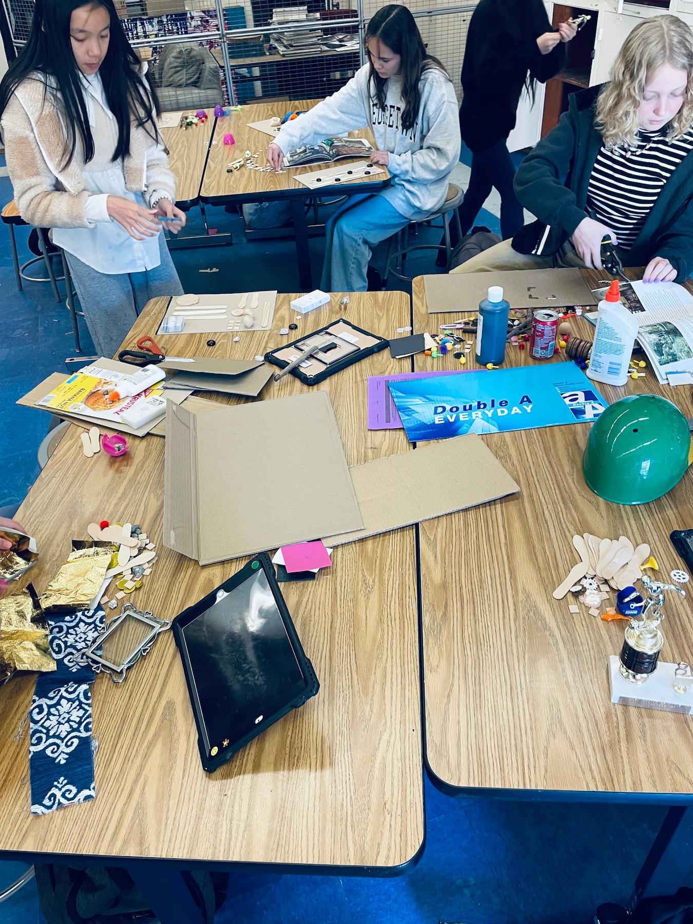 Paul Revere middle schoolers gather their cardboard and found object materials for assemblage project with artist Calder Kamin