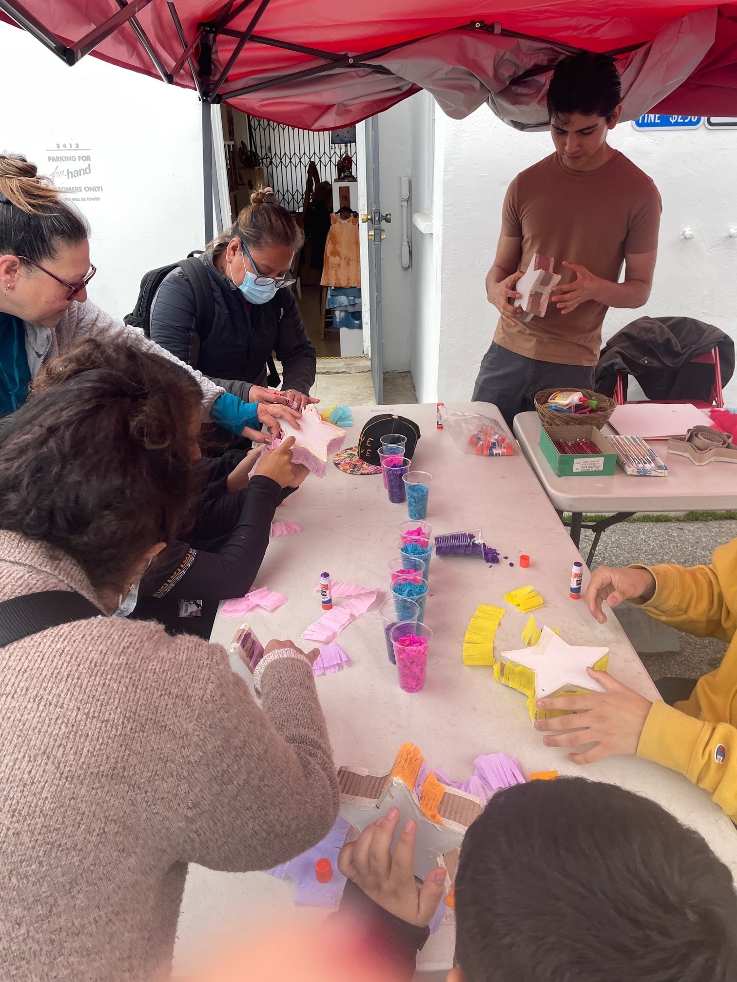 Van Nuys high schoolers and Amazing Piñata Studios teacher craft star piñatas together with crepe paper