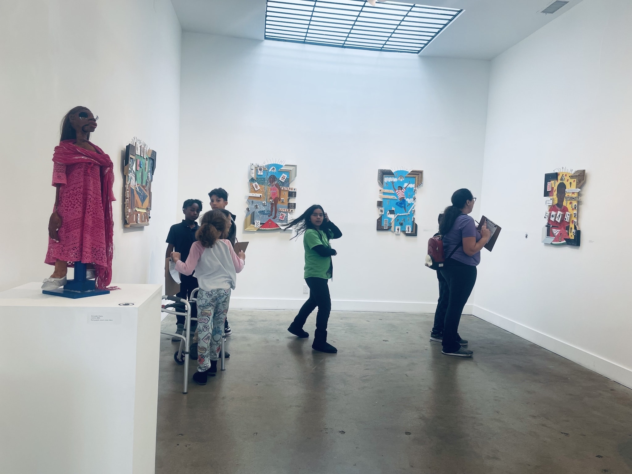 Candid group photo of Rosewood elementary schoolers studying Schroeder Cherry's Future Voter artworks