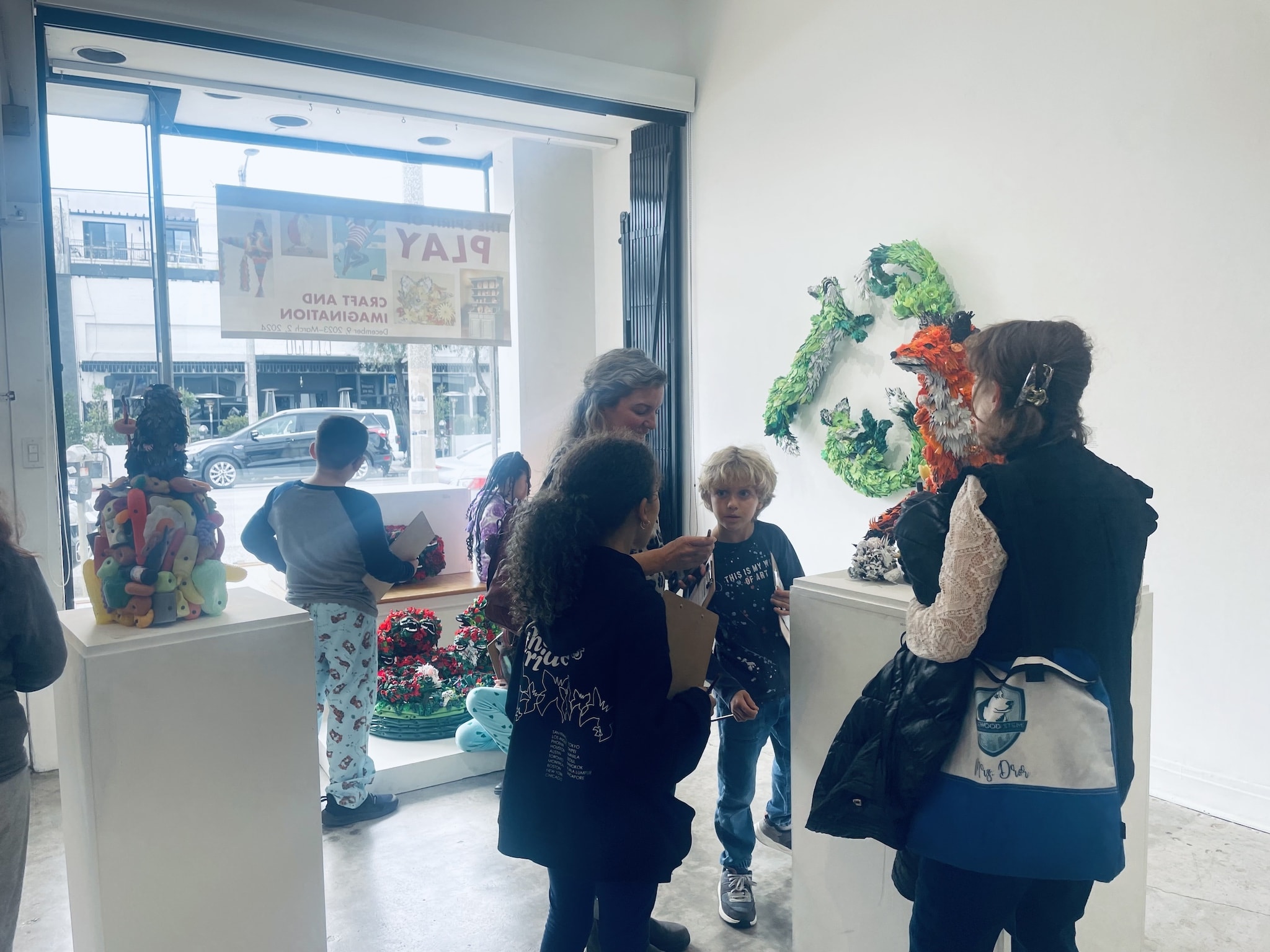 Rosewood Elementary 4th grade classmates, a chaperon, and their teacher ooh and ahh over the many colorful plastic/recycled art sculptures by Calder Kamin