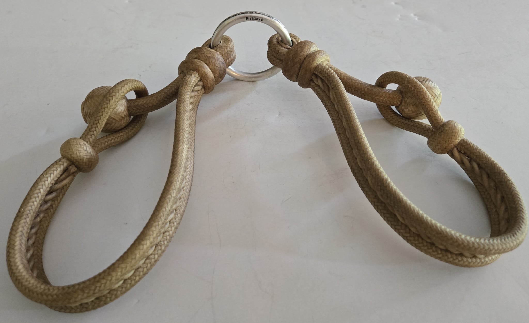 Intricately braided rawhide hobbles, joined with a sterling silver ring