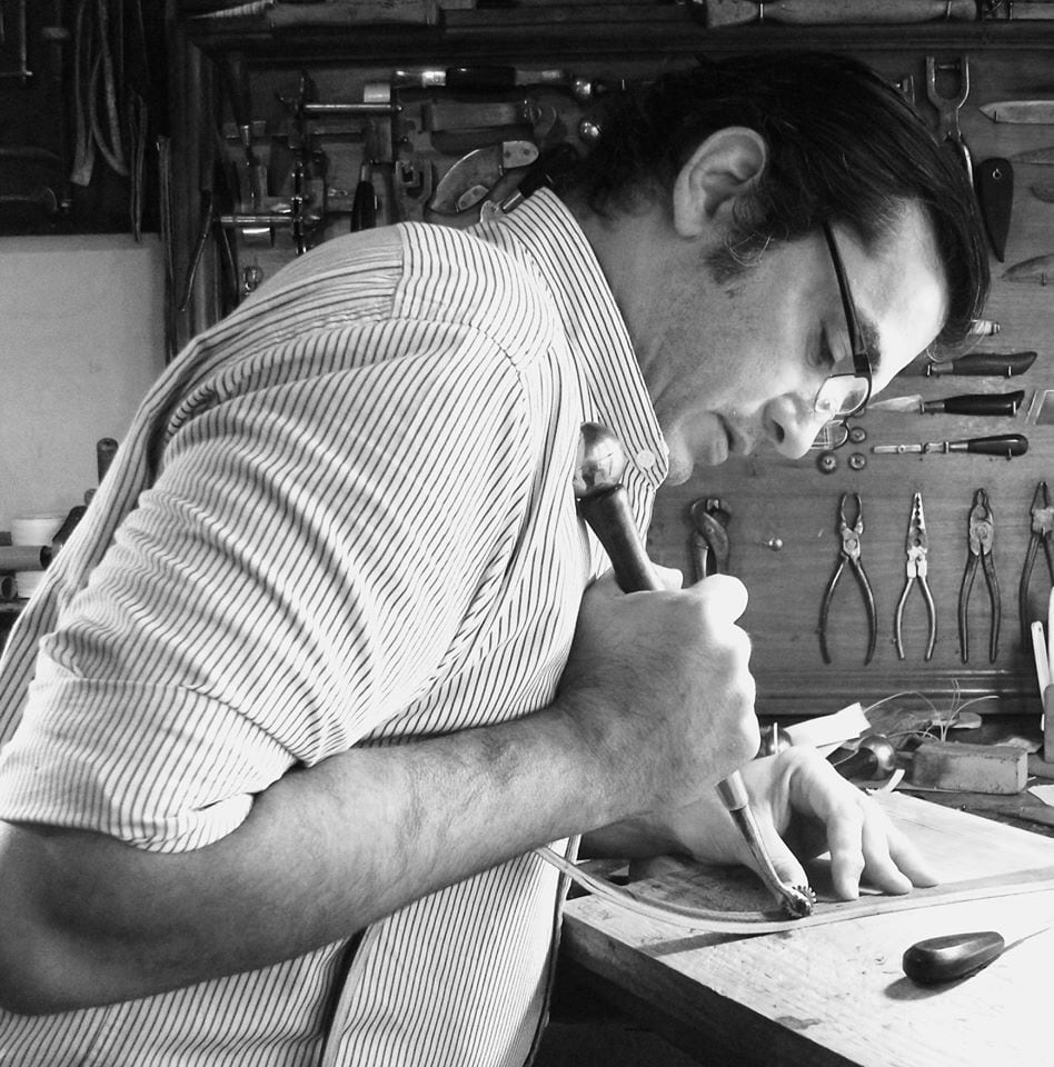 Black and white photo of Pablo Lozano in his workshop prepping rawhide for braiding