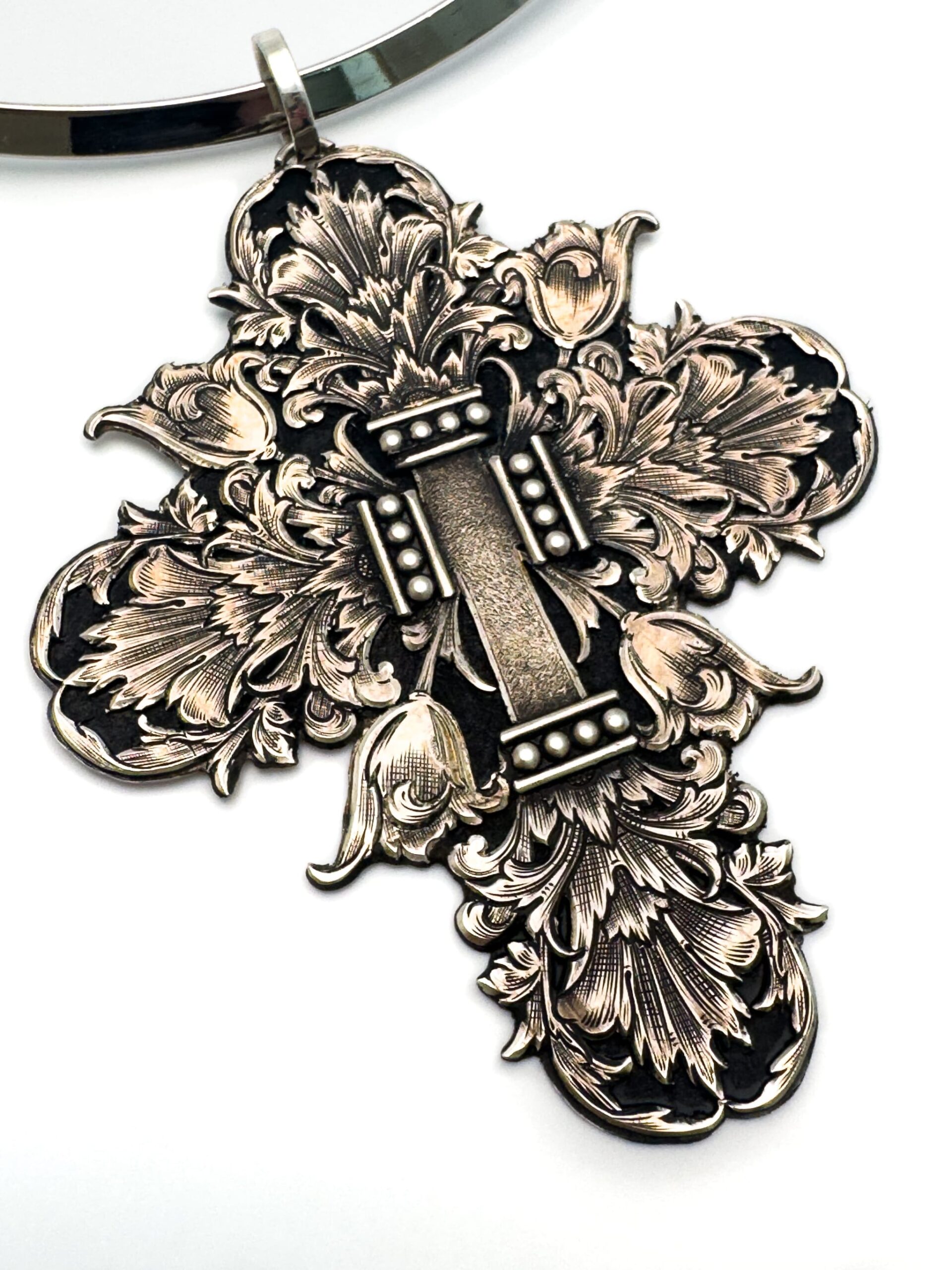 Ornate silver cross Pendant engraved with floral patterns